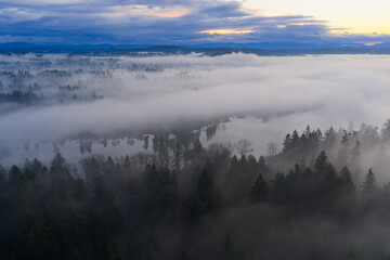 A blanket of fog drifts over the Willamette River just south of Portland, Oregon. The Pacific Northwest is known for its scenic forests, waterfalls, and rivers, as well as its wet weather.