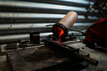 Molten gold poured into mold for jewelry fabrication.