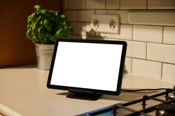 Fototapeta premium Blank digital tablet on a modern kitchen countertop for recipe display and smart home use concept