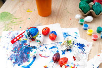 Colorful egg decorating activity with various materials on a table during a crafting session in the afternoon