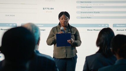 African american woman makes a speech at international summit in conference hall, presentation with...