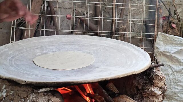 Traditional Mexican clay griddle (comal) over wood fire ready for cooking.
