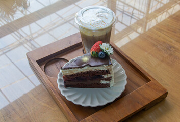 Coffee and chocolate cake with ice coffee in coffee shop.