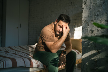 Man experiencing headache, stress and fatigue in bedroom