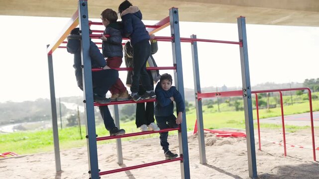 Children and adults climbing monkey bars together at playground