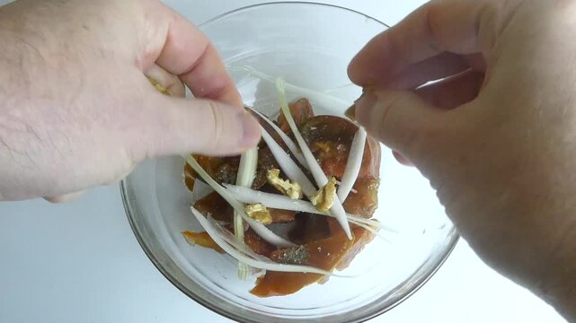 Chef adding walnuts to a salad with dried persimmons and onions