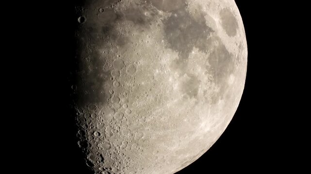 A close-up of the Moon dominates the frame, more than half illuminated in a gibbous phase. The surface reads like a weathered, pocked landscape