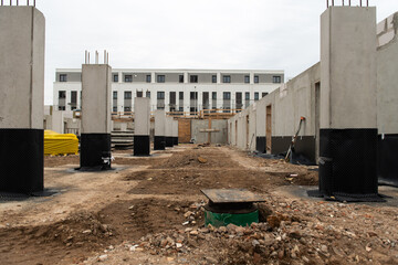 construction site showing an unfinished apartment building. House under construction. shell construction with building material, tools and scaffolding. future property real estate