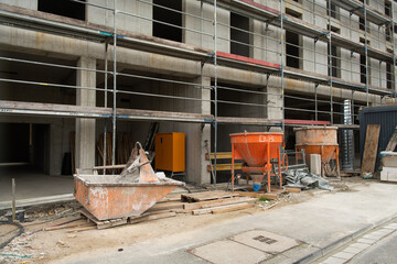 construction site showing an unfinished apartment building. House under construction. shell construction with building material, tools and scaffolding
