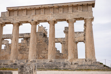 Fototapeta premium Wide view of ancient stone columns forming the remains of a classical Greek temple. The symmetrical layout and eroded surfaces highlight centuries of history and architectural mastery.