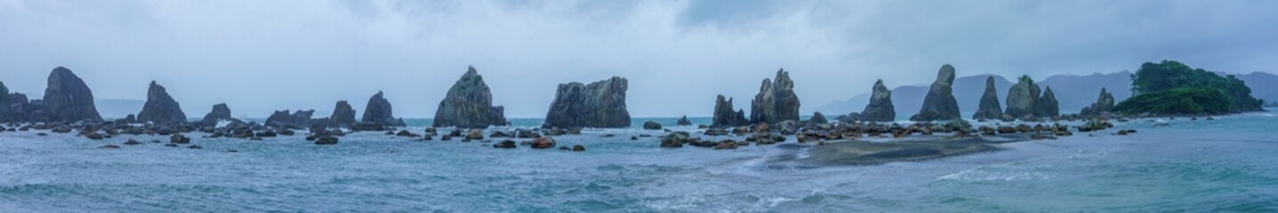 和歌山県串本町、橋杭岩のパノラマ風景。雨の中の荒々しい海岸美。