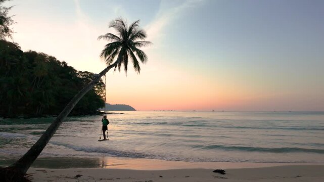Stunning vistas capture the peaceful moments on Koh Kood shore as the sun sets. A traveler enjoys the calm waters and picturesque landscape, creating lasting memories in Thailand paradise.