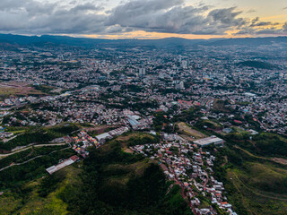 Obraz premium Beautiful aerial view of Tegucigalpa, capital of Honduras, surrounded by mountains and the city glowing across the urban valley