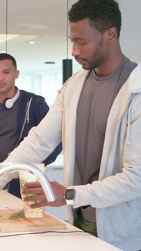 Vertical video: Placing cup on board, man in grey hoodie locking cup into motor base making drinks