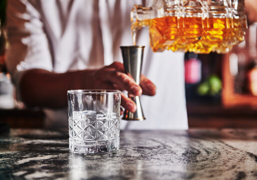 Bartender pouring a whiskey cocktail