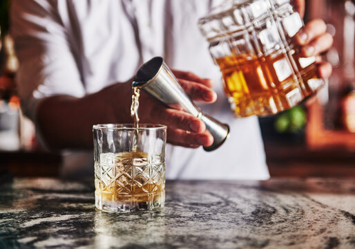 Bartender pouring a whiskey cocktail
