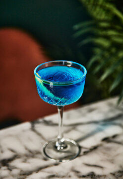 Blue cosmopolitan cocktail in a restaurant setting 
