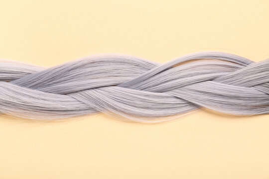 Braided grey hair on beige background