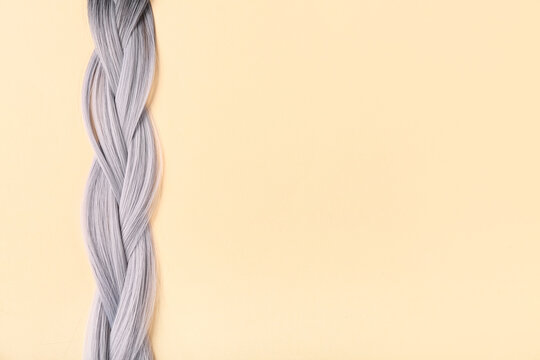 Braided grey hair on beige background
