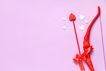 Naklejka premium Composition with cupid's bow, arrow and paper hearts on lilac background. Valentine's Day celebration