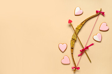 Naklejka premium Composition with cupid's bow and heart shaped cookies on color background. Valentine's Day celebration