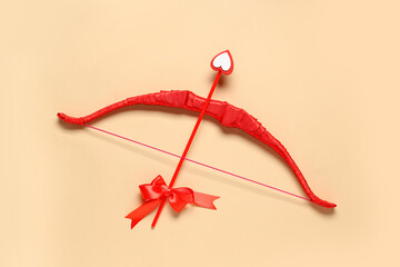 Naklejka premium Red cupid's bow on color background. Valentine's Day celebration