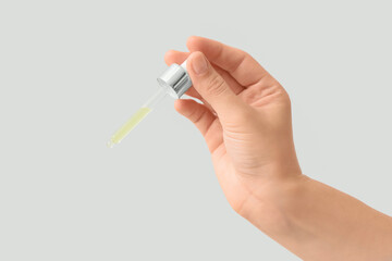 Female hand with essential oil on white background