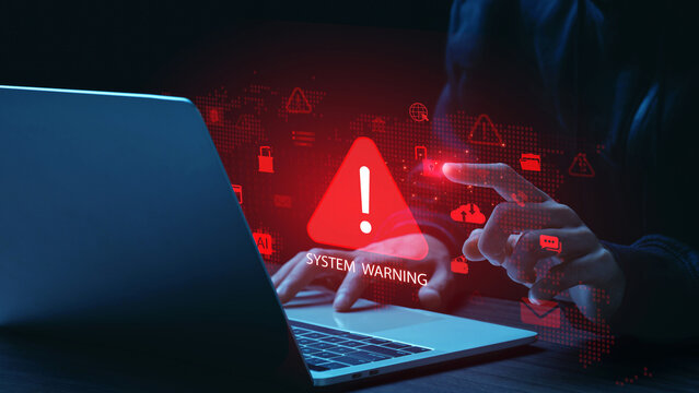Cyber security system warning concept showing hacker hands using laptop with digital alert icons, data breach risk, malware attack, phishing scam, network protection, information security technology.