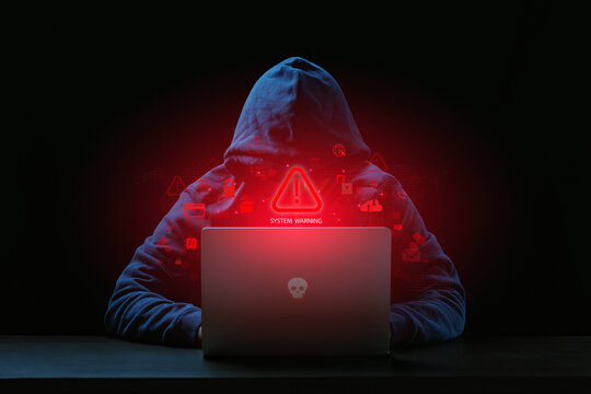 Cyber security warning concept with hacker using laptop with displaying warning icons , system alert, data breach, malware attack, phishing scam, danger of cyber threats and digital security risks.