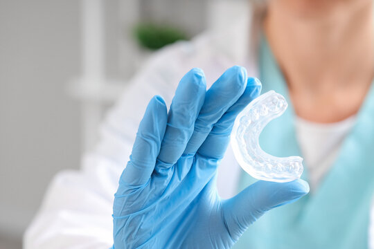Female dentist with occlusal splint in clinic, closeup