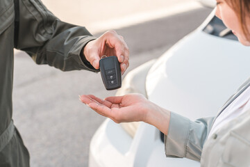 A male auto mechanic staff member taking car keys from a female customer © buritora
