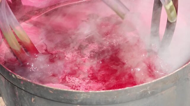 Cotton yarn is dyed with lac dye to obtain natural colors using a traditional method in a hot pot.