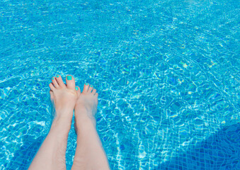 Relaxation by the Poolside With Feet Dipped in Refreshing Blue Water