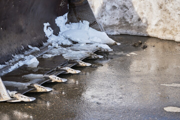 Excavator Bucket Teeth Removing Snow on Asphalt