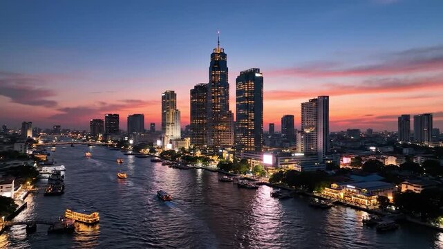Cityscape riverfront at twilight with illuminated buildings and boats