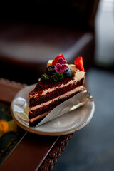 A beautiful blueberry and strawberry cake topped with lemonade, served on a plate, with a cafe as the backdrop.