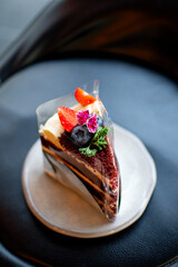 A beautiful blueberry and strawberry cake topped with lemonade, served on a plate, with a cafe as the backdrop.