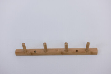 Simple wooden wall hanger rack with four hooks or pegs. minimalist holder for coat, hat, and...