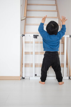 階段前のベビーゲートと立つ幼児