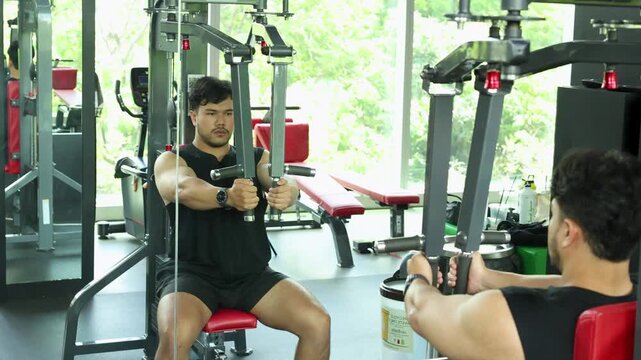 Man Performing Chest Press Exercise on Gym Machine