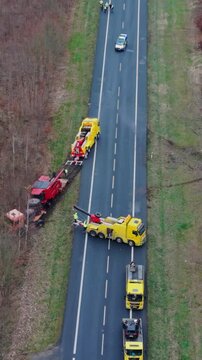 Vertical Screen Aerial View Traffic Diverted Around Recovery Site, Cones And Marshal Control Lane, Tow Trucks And Service Vehicles Forming Safety Perimeter, Forest Verge, Poland