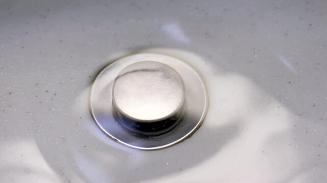 シンクに溜めた水を排水口に流す