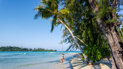 Relaxation on secret beach in koh kood thailand with swing under palm trees