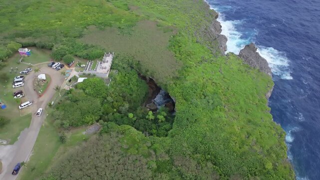 Discover the mesmerizing 'Grotto Blue.' This aerial footage captures The Grotto in Northern Saipan, a world-renowned collapsed limestone cavern and a premier destination for scuba divers. The video sh