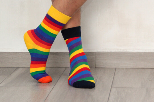 Feet with mismatched socks, different colors and designs for World Down Syndrome Day, to highlight inclusion and the uniqueness of each person