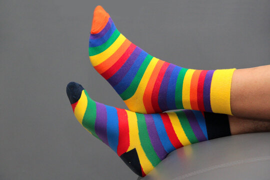 Feet with mismatched socks, different colors and designs for World Down Syndrome Day, to highlight inclusion and the uniqueness of each person