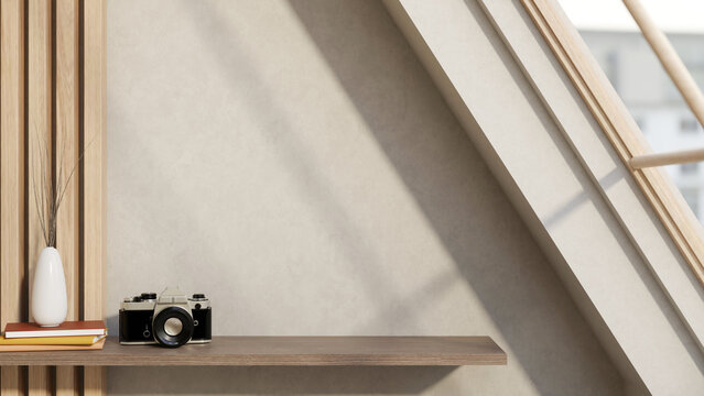 White flower vase on books and camera on hanging wooden shelf on wall and sunlight from roof window.