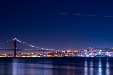 Fototapeta premium Lisbon bridge and port area illuminated at night