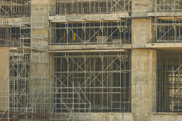 Large construction site with extensive scaffolding covers concrete structure of building under construction, showcasing complexity and scale of modern architecture