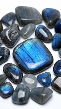 Close-Up of Polished Labradorite Gemstones With Blue Iridescence on White Background